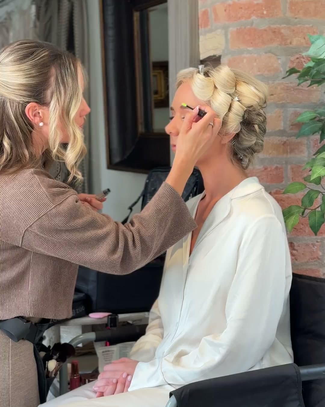 Abigail doing a bride's eye makeup, her hair still in rollers